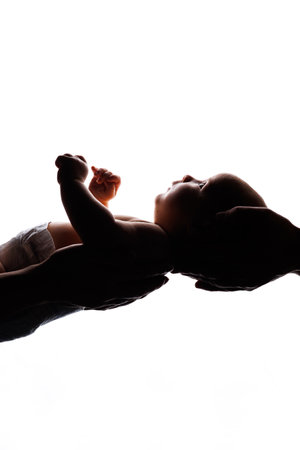 Little cute baby lying in arms on white background. A newborn baby.の写真素材