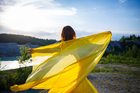 Summer lifestyle of stunning happy woman running in nature. In a long yellow dress. Romantic mood. Enjoying the sunshine. Sunny day. Selective focusの写真素材