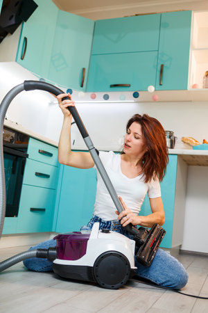 Young woman housewife plays with a vacuum cleaner. Fun apartment cleaningの写真素材