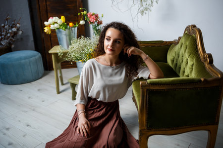beautiful girl model with curls in a dress posing in beautiful arrangements. The beginning of spring with flowersの写真素材