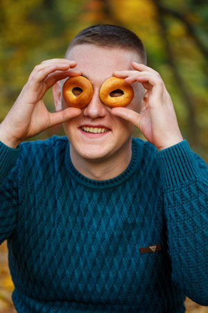 A guy in the autumn forest with cookies