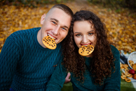 A guy and a girl in the autumn forest with cookies