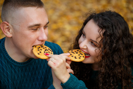 A guy and a girl in the autumn forest with cookiesの写真素材