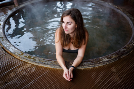 Girl in the pool with hot water on the terrace, spa body treatments. Relax in the open air,...