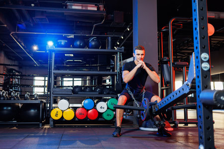 Handsome muscular man performing heavy exercises in the gym. Healthy lifestyle