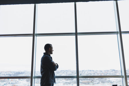 Young business man holding a phone. In an office or business center against the background of large...
