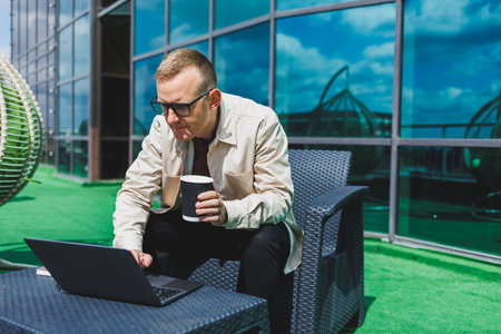 Confident young businessman, dressed in formal wear and stylish glasses, calls on a smartphone while...