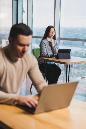 Business woman working on online project looking at laptop at workplace, professional in office,...