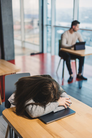 Business woman working on online project looking at laptop at workplace, professional in office, sitting at desk with computer, modern work online in office cafeの写真素材