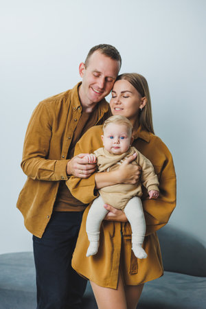 A happy mother and father hold their 4-month-old son in their arms. Family photo of happy parents...