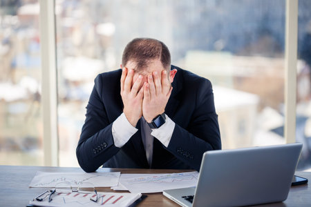 Adult male businessman, teacher, mentor is working on a new project in the office and is nervous....