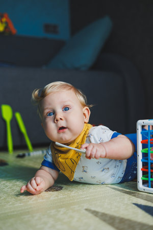 The child is lying on the mat, playing with soft balls. Educational toys for the motor skills of the...