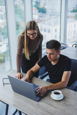 Business woman and businessman are looking for something in the laptop. The concept of business...
