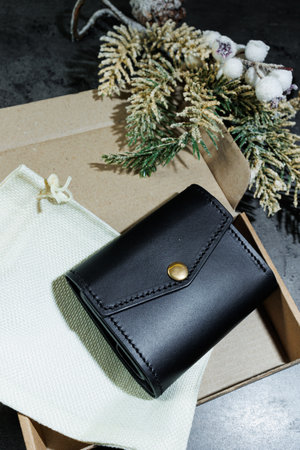 Black handmade men's wallet with compartments for cards and cash.