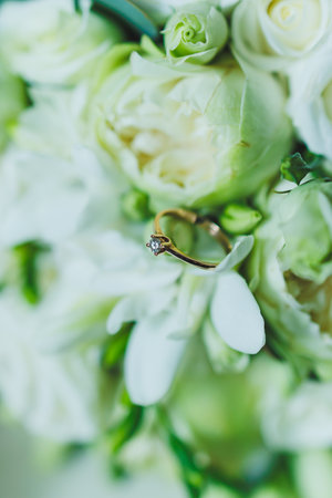 Precious gold rings for newlyweds on a background of flowers. Wedding rings for a couple.の写真素材