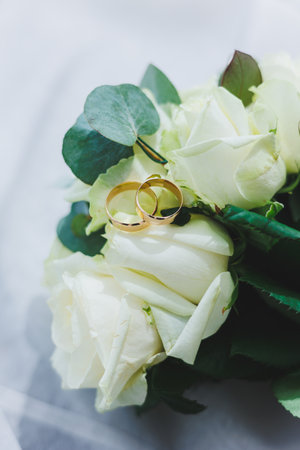 Precious gold rings for newlyweds on a background of flowers. Wedding rings for a couple.の写真素材