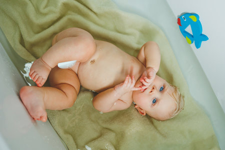 Adorable of asian newborn baby bathing in bathtub.mother bathing her son in warm water.Happy...