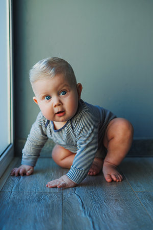 Cute little boy in a bodysuit with a smile on his face. The child looks at the camera, smiles....