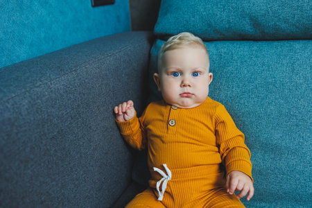 Cute little boy in a yellow suit. Clothes for babies.