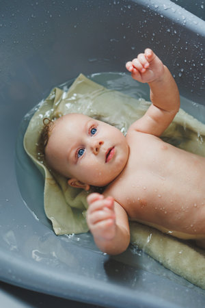 Bathing a baby in the bathroom. Baby skin care. Baby hygiene.