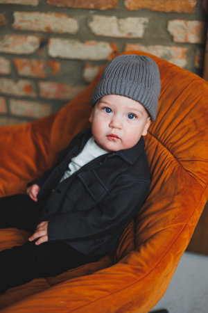 A little one-year-old boy in a cap and shirt. A baby with a smile on his face. Clothes for babies.の写真素材
