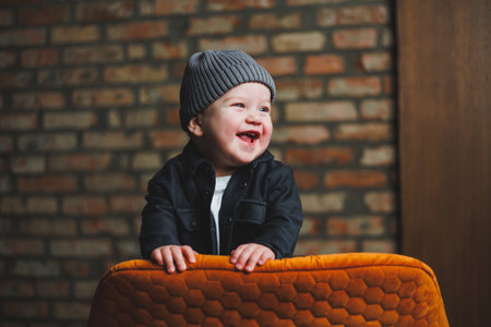 A little one-year-old boy in a cap and shirt. A baby with a smile on his face. Clothes for babies.の写真素材