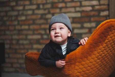 A little one-year-old boy in a cap and shirt. A baby with a smile on his face. Clothes for babies.の写真素材