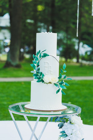 A sweet holiday cake on the background of a photo zone for the newlyweds. White multi-tiered cake.の写真素材
