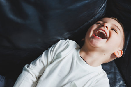 A 3-year-old boy in a white sweater and pants with a smile on his face. Little boy in stylish clothes.の写真素材