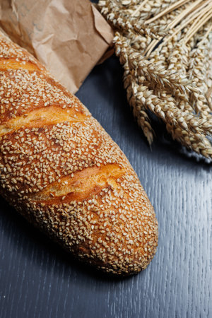Fresh delicious wheat bread sprinkled with sesame seeds. Homemade baking. Craft bread