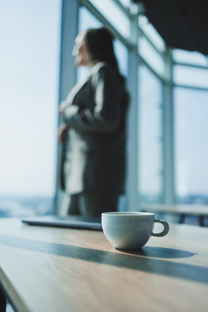 A young woman in a gray suit is working on a laptop in a cafe. Beautiful girl in casual clothes.の写真素材