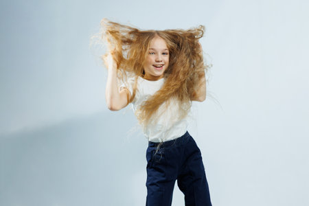 Laughing girl in white t-shirt and jeans portrait isolated on white background. The concept of children's emotions, childhood.の写真素材