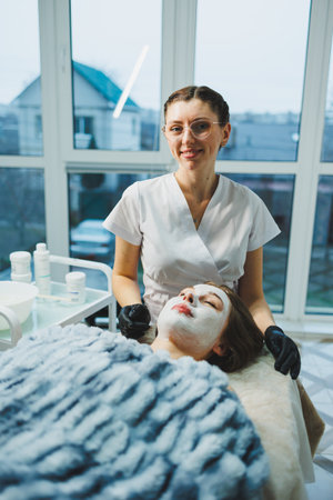 Applying a mask on a woman's face by a beautician. Facial skin care.