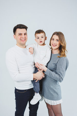 A happy married couple with a little son. Mom, dad and smiling son. Stylish family.の写真素材