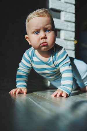 Happy smiling child. A cute little newborn baby boy with a smiling face is crawling on the floor....