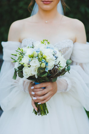 The bride in a white dress holds a bouquet of fresh flowers in her hands. Bride's bouquet.の写真素材