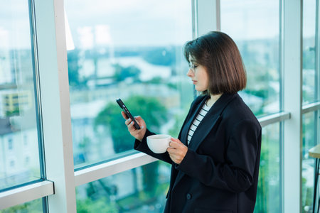 Young business woman talking on the phone while working in a modern office. Businesswoman customer sales manager of the company in a suit, at the workplace.の写真素材