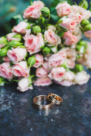 Wedding rings for newlyweds on a background of flowers. Precious wedding ringsの写真素材