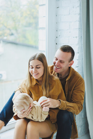 Mom and dad are playing with their baby on a white background. A baby in the arms of his loving parents.の写真素材