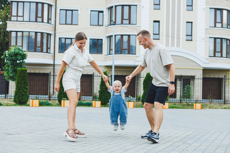 A happy married couple is playing with their son outside on a summer day. The concept of a happy...