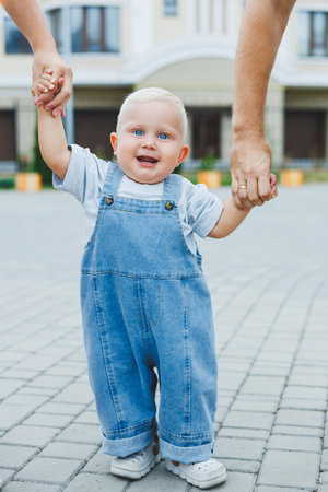 A happy married couple is playing with their son outside on a summer day. The concept of a happy family. Dad, mom and son are playing in the yard.の写真素材