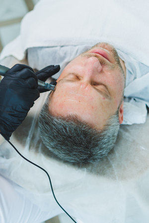 Male cosmetology in a beauty salon. A man takes care of his facial skin.の写真素材