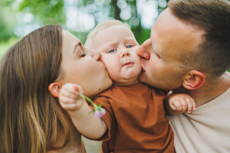 Mom, dad and little son on a walk in the park. Concept of parent time with child. Happy family couple with child in nature.の写真素材