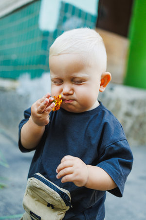 Emotional cute toddler boy on a walk in the park. A 1-year-old boy is running and smiling.の写真素材
