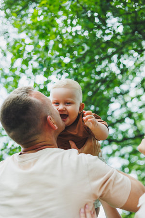 Cute dad plays with his little son and carries him in his arms. Dad and son game.