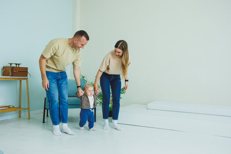 A happy family couple with a little son in their arms. Mom, dad and baby are hugging.の写真素材