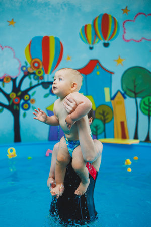 A child learns to swim in a pool with a coach. Teaching children to swim.の写真素材