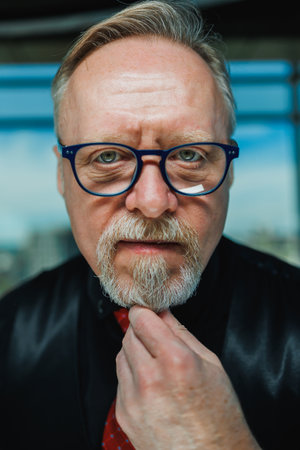 Bearded old man grimacing in glasses. The old grandfather's roof is falling and he grimaces.の写真素材