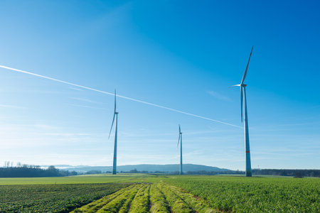 Wind energy generation. Electricity is generated by a wind turbine against a blue sky. Sustainable...