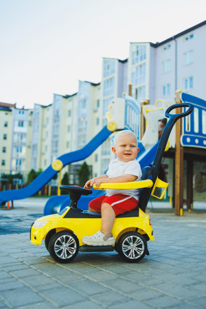 A little boy rides a toy car. Toy car for babies. Children's car for skating.の写真素材